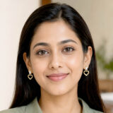 Gold-tone open heart drop earrings with rectangular clear stones on a white background.